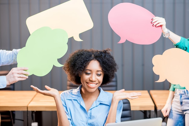 Photo portrait of creative african ethnicity businesswoman sitting with thought bubbles at the office