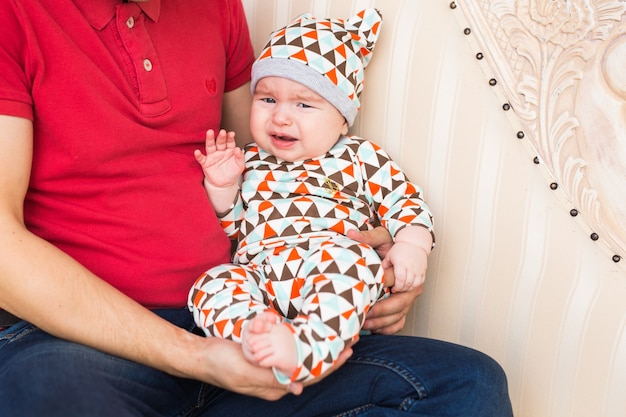 Portrait of crying baby boy in the room