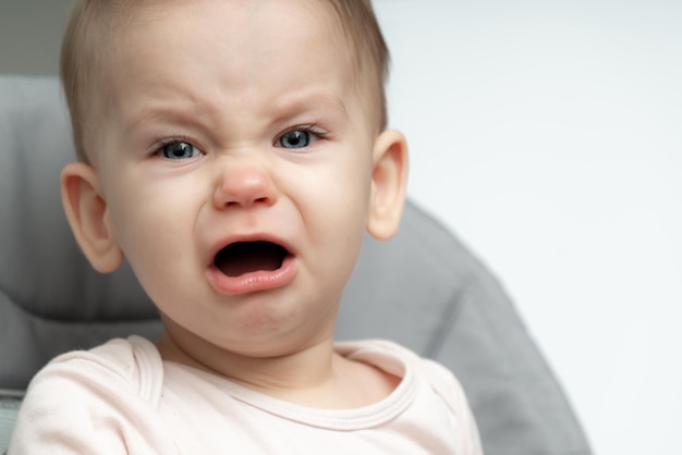 Photo portrait of crying year old baby upset of being hungry and tired