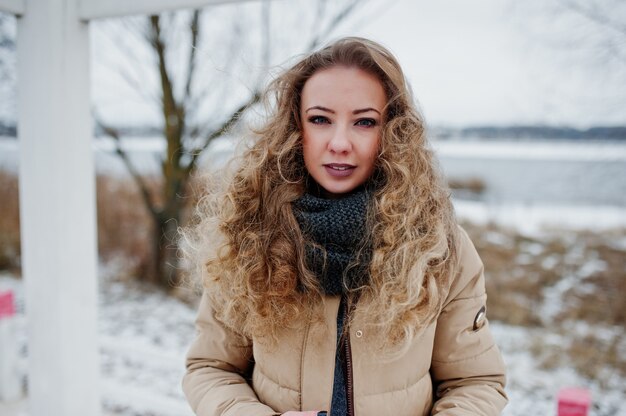 Portrait of curly blonde girl at winter day.