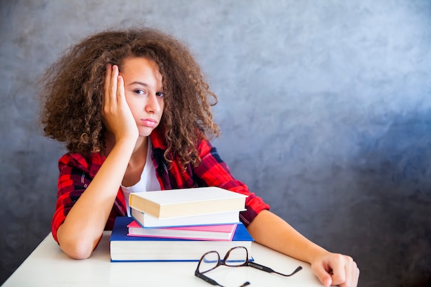 Portrait of curly hair teen girl above book