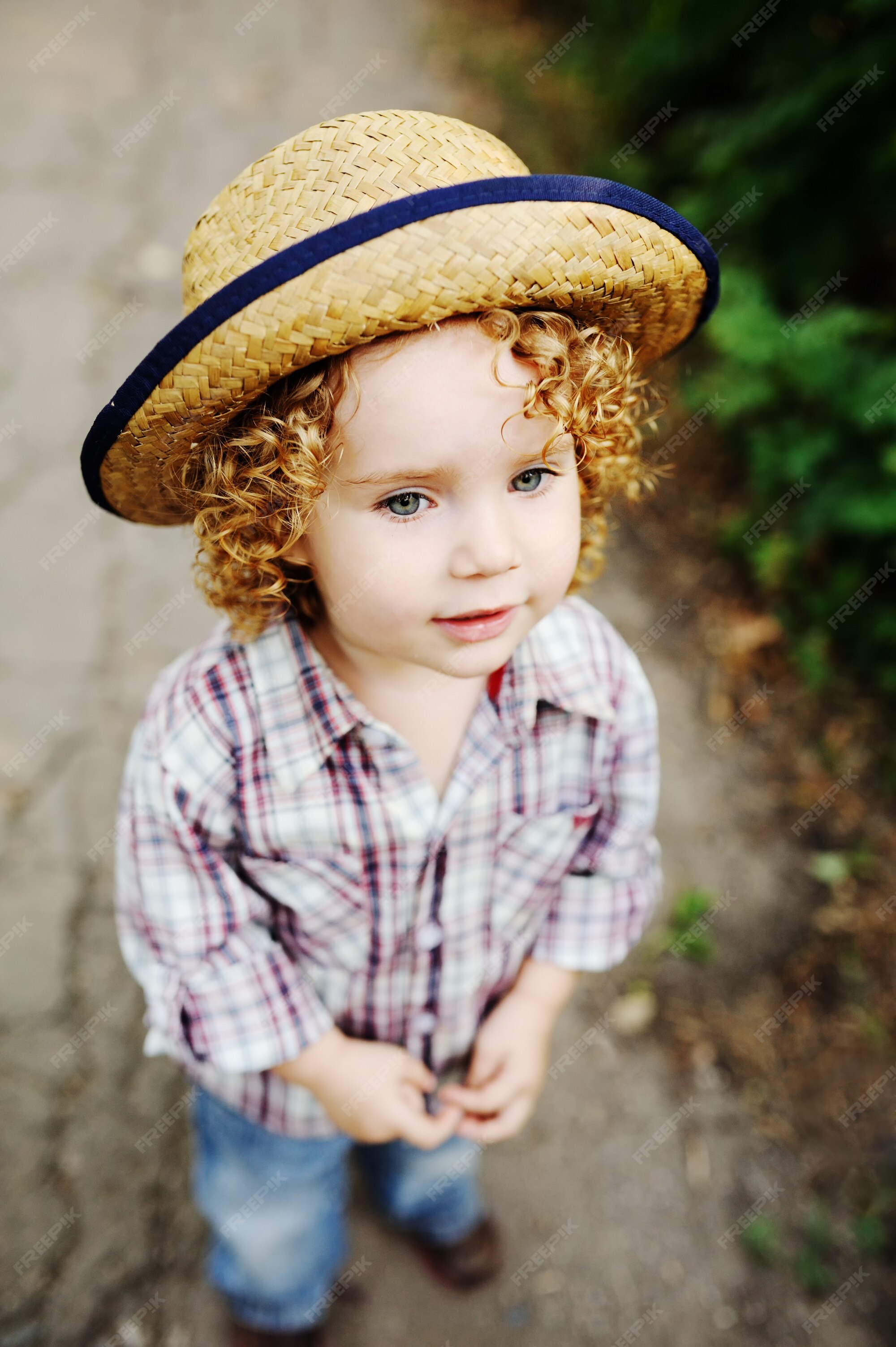 Image of Little girl with curly red hair in straw hat