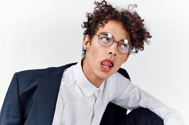 Photo portrait of a curlyhaired guy in a shirt in a jacket and glasses