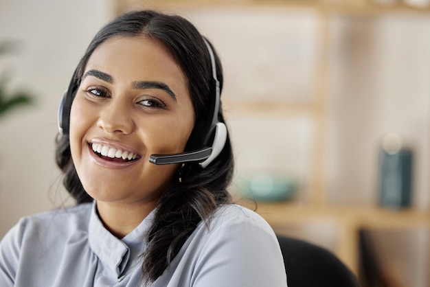 Portrait customer support or happy woman in call center with mic on headset for friendly services Girl virtual assistant smile or face of telemarketing sales agent talking online in telecom office