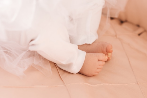 Portrait of a cute 6-month-old baby, a newborn girl lying in a baby crib