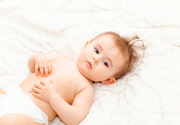 Portrait of a cute 6 months baby lying down on a blanket. little happy baby