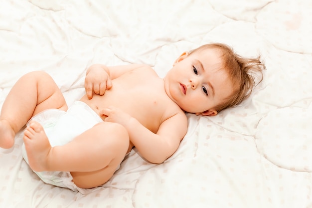 毛布の上に横たわっているかわいい6ヶ月の赤ちゃんの肖像画。小さな幸せな赤ちゃん