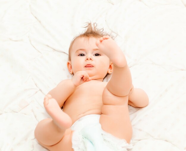 Portrait of a cute 6 months baby lying down on a blanket. little happy baby