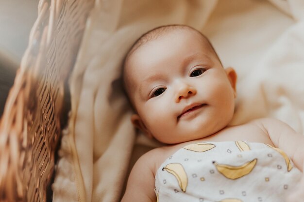 Portrait of a cute active baby lying in a crib smiling and looking at the camera Copy space Happy motherhood concept