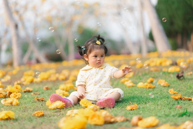 Portrait of cute asian baby girl in the flowers garden