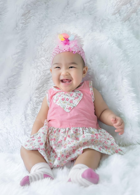 Portrait of cute asian baby in pink dress on carpet woolhappy baby conceptsmile