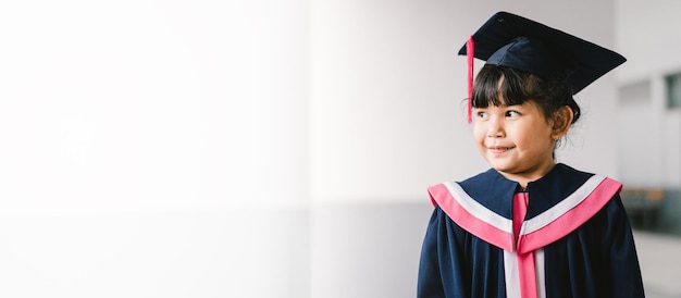 学校で卒業ガウンとかわいいアジアの卒業した女子高生の肖像画