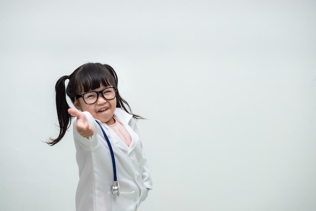 Portrait of cute asian little girl in doctor uniform on white background