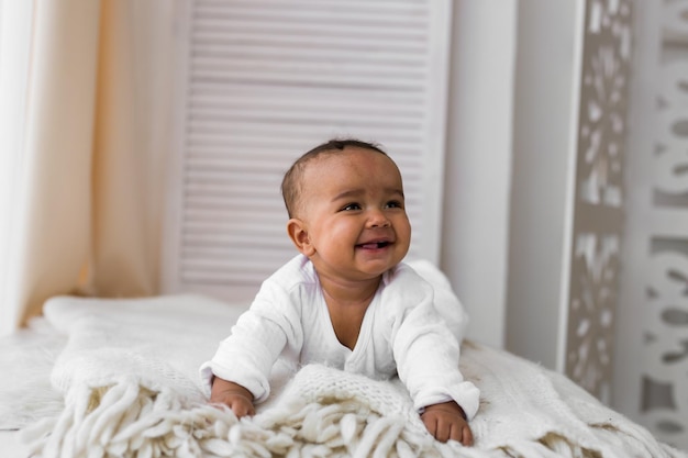 Photo portrait of cute baby boy on bed at home