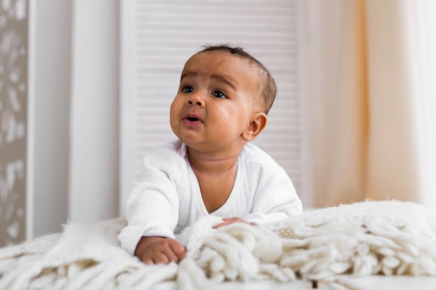 Portrait of cute baby boy on bed at home