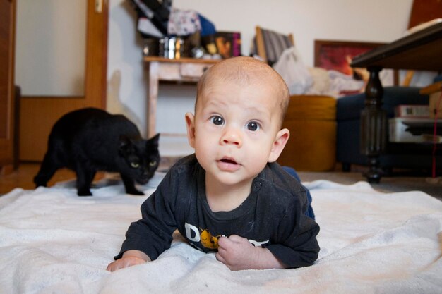 portrait of cute baby boy by cat at home
