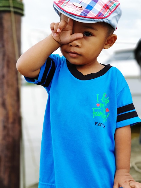 Portrait of cute baby boy gesturing while standing outdoors