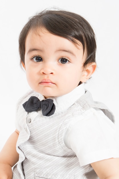 Portrait of a cute baby boy looking at camera with his big eyes Adorable child wearing bow tie