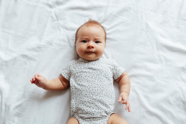 portrait of cute baby boy lying on bed at home