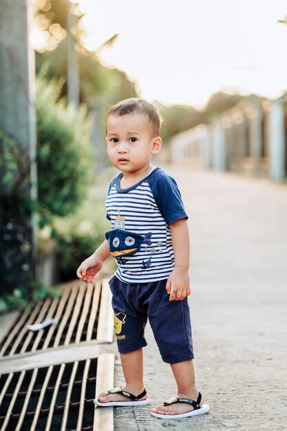 Portrait of cute baby boy walking on footpath