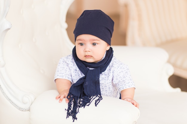 Portrait of cute baby boy wearing blue hat.