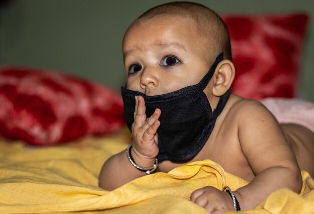 Portrait of cute baby girl on bed at home