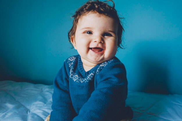 Portrait of cute baby girl on bed at home