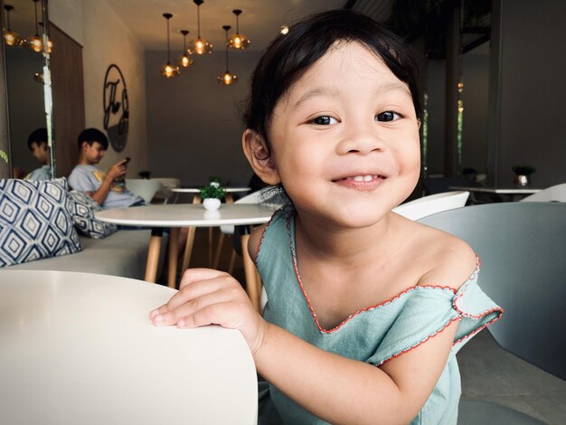 Photo portrait of cute baby girl at cafe