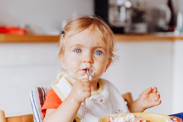 portrait of cute baby girl eating at home