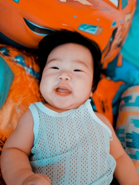 Portrait of cute baby girl lying on bed