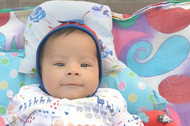 Portrait of cute baby girl lying on bed