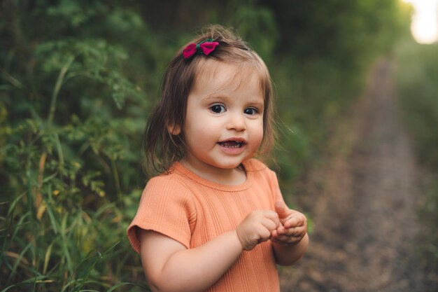 Portrait of a cute baby girl posing on a country road Freedom travel Nature landscape Beautiful girl portrait Road trip Active travel Summer nature