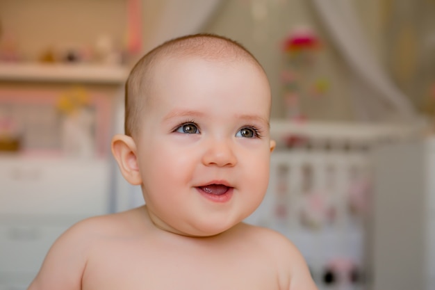 웃는 귀여운 아기 소녀의 초상화는 카메라에 보인다