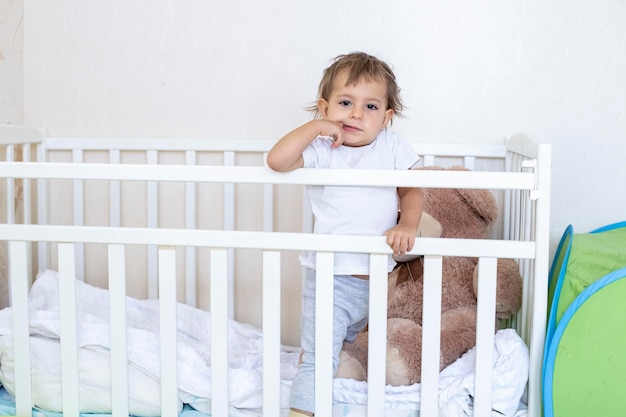 Foto ritratto di una bambina carina in piedi nella culla a casa