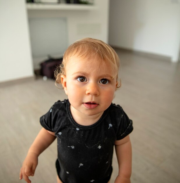 Photo portrait of cute baby girl standing at home