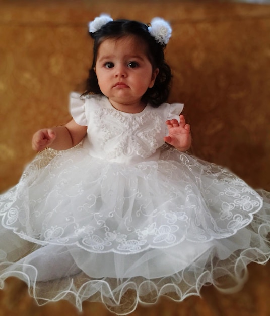 Photo portrait of cute baby girl in white dress