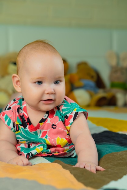 Portrait of a cute baby girl with blue eyes in colorful dress