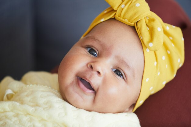 Portrait of cute baby girl with bow on her head looking at camera