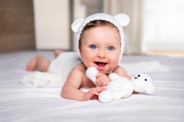 portrait of cute baby girl with toy on bed