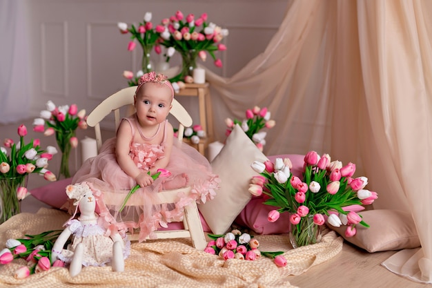 Portrait of a cute baby girl with tulips