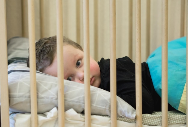 Photo portrait of cute baby lying on bed at home