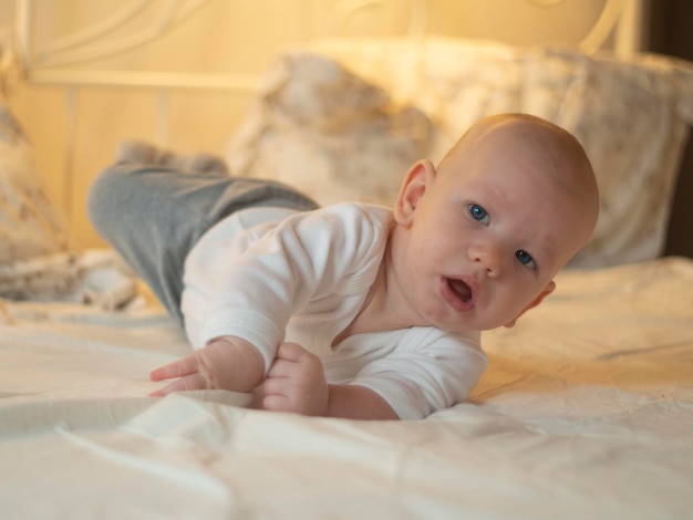 Portrait of cute baby lying on bed at home