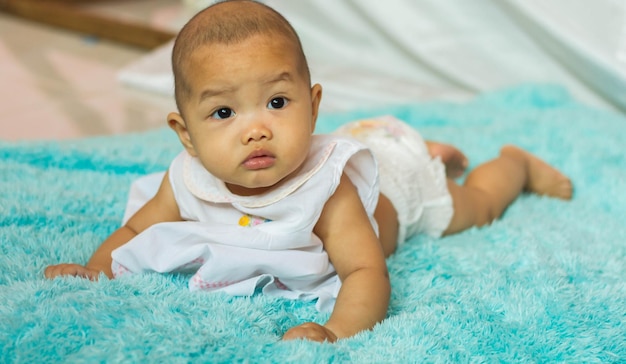 Photo portrait of cute baby lying on bed