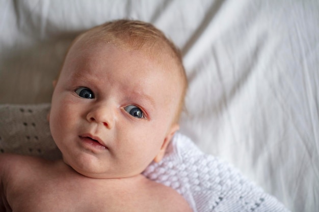 Portrait of cute baby lying on bed