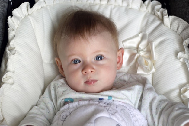 Portrait of cute baby lying on stroller