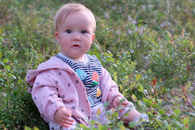 Portrait of cute baby sitting on field