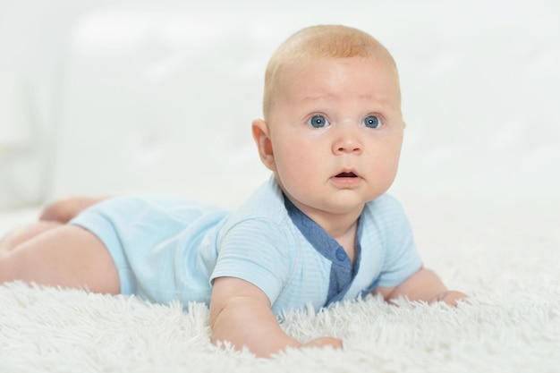 Portrait of cute beautiful baby boy on bed