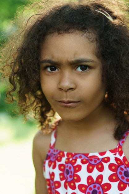 Portrait of cute black girl in a city park