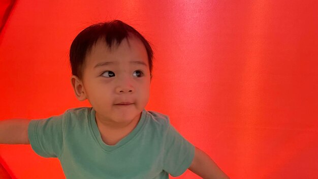 Portrait of cute boy against red wall