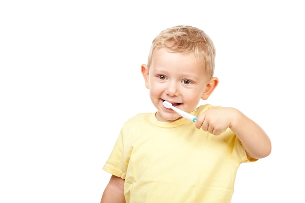 Photo portrait of cute boy brushing teeth against white background